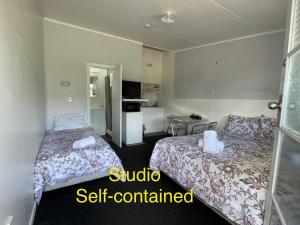 a hotel room with two beds and a kitchen at Oasis Motel & Holiday Park Turangi in Turangi