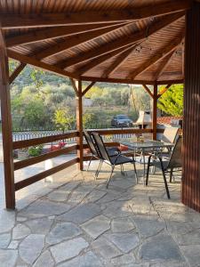 a wooden pavilion with a table and chairs on a patio at Veni's Apartments in Potos