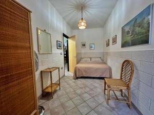 Un dormitorio con una cama y una silla en una habitación. en Casa Vacanza Rita, en Marina di Pescoluse