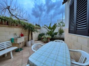 un patio con mesa, sillas y fregadero en Casa Vacanza Rita, en Marina di Pescoluse