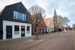 a cobblestone street with houses and a church at In de Mid - Prachtige appartementen in hartje Joure in Joure