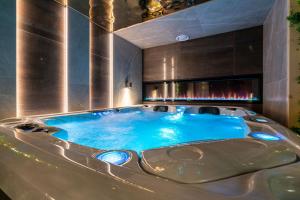 a hot tub in a room with a fireplace at Piaseckiego Residence SPA in Zakopane