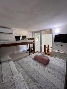 1 dormitorio con 2 camas y 1 litera en casa Beira mar 2° praia, en Morro de São Paulo