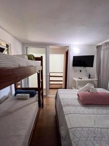 1 dormitorio con 2 literas y TV de pantalla plana en casa Beira mar 2° praia, en Morro de São Paulo