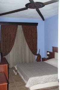 um quarto com uma cama e uma ventoinha de tecto em TSIGOURA VERDE RESORT em Mikrós Prínos