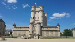 ein Schlossgebäude mit einer Flagge darüber in der Unterkunft Nad Ins in Vincennes