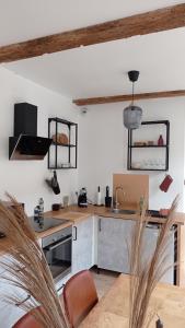 a kitchen with white walls and a wooden counter top at Les Réserves du Beffroi in Aire-sur-la-Lys