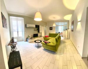 a living room with a green couch and a kitchen at Bella 'Mbriana in Avellino