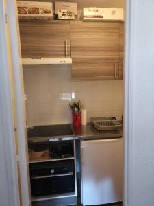 małą kuchnię z drewnianymi szafkami i blatem w obiekcie Appartement rénové avec parking plein centre w mieście Samoëns