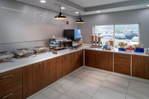 una cocina con armarios de madera y una barra con comida en Holiday Inn Express - Charleston/Kanawha City, an IHG Hotel, en Charleston