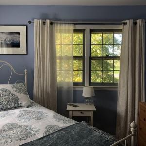 een slaapkamer met een bed en 2 ramen bij A Cool Pad Vacation Rental: 4 Bedroom 3.5 bath in Wallkill