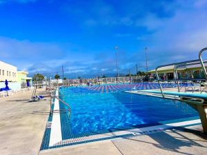 a large swimming pool with blue water and chairs at SW Florida Luxury Modern Retreat, King Bed Suite , Close to Beaches / Golfing / Fishing / Air Ports , 2023 Built in Rotonda West