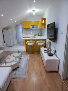 a living room with a couch and a kitchen with yellow cabinets at Vila Nastovski in Veles