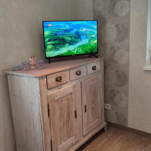 a flat screen tv on top of a wooden cabinet at Kleine Auszeit - Ferienwohnung Heideberg - "Rhein" in den Urlaub in Bacharach