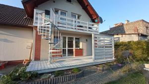 a house with a deck and a staircase at Apartament Marzanna in Spytkowice