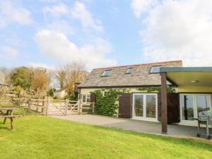 a cottage with a picnic table and a fence at Higher Kernick Stable in Bodmin