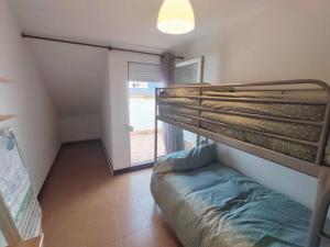 a bedroom with a bunk bed and a window at Piso en Ajo con piscina comunitaria in Ajo