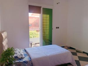 een slaapkamer met een bed en een glazen schuifdeur bij 卡萨布兰卡豪华别墅，距离穆罕默德5机场10分钟 in Casablanca