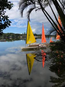 deux voiliers sur un lac avec réflexion dans l'eau dans l'établissement Hostel Floripa Lake House Lagoa Conceiçao 24HORAS, à Florianópolis