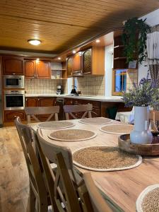 a kitchen with a wooden table with chairs and a tableasteryasteryasteryasteryastery at Chalupa U rybníčku in Krásná Lípa