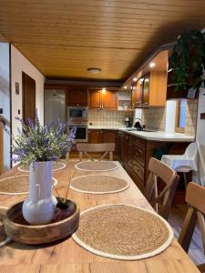 a kitchen with a table with a vase of flowers on it at Chalupa U rybníčku in Krásná Lípa +50 photos