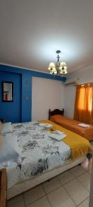 a bedroom with two beds and a blue wall at Guest House Santiago in Santiago del Estero