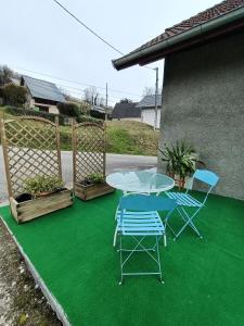 patio ze stołem i krzesłami na zielonym piętrze w obiekcie Chez ma Grand-mère w mieście Saint-Félix