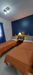 a bedroom with two beds and a blue wall at Guest House Santiago in Santiago del Estero