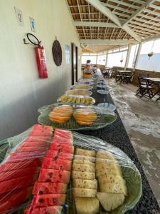 a long line of plates of food on a table at Pousada Corais de Maracajaú in Maracajaú