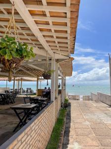 a patio with tables and the ocean in the background at Pousada Corais de Maracajaú in Maracajaú +40 photos