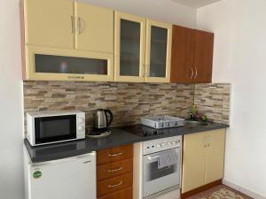 a small kitchen with a microwave and a stove at Apartment Vrbani in Zagreb