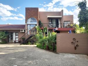 uma casa com uma escada em frente em Arista Guesthouse em Bloemfontein