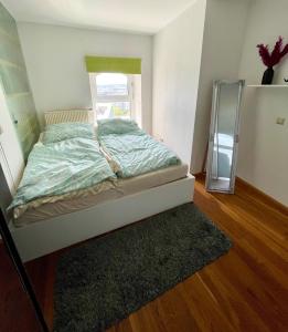 Bett in einem kleinen Zimmer mit Spiegel in der Unterkunft Una in Wien