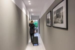 a woman walking down a hallway with a suitcase at Octavia comfort bungalows with amazing view in Korinthos