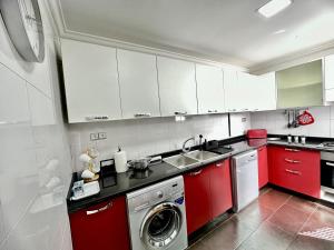 a kitchen with red cabinets and a washing machine at La Terrasse de l'agdal in Rabat