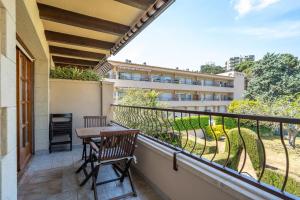 a balcony with a table and chairs and a building at Hauzify I Apartament Bòvila Mar in S'agaro