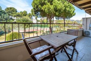 a wooden table and two chairs on a balcony at Hauzify I Apartament Bòvila Mar in S'Agaro