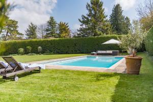 een zwembad in de tuin van een huis bij Burleigh House by Bloom Stays in Charing
