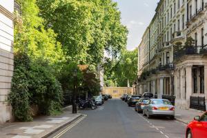 a street with cars parked on the side of the road at Knightsbridge - Sumptuous Flat - Hyde Park in London