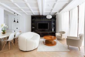 a living room with a white chair and a table at Knightsbridge - Sumptuous Flat - Hyde Park in London