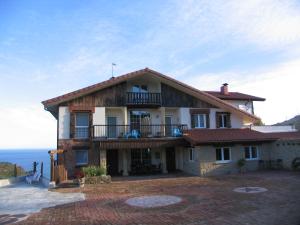 a house with a balcony and the ocean in the background at Igeldo in Orio