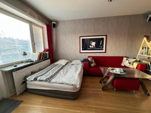a bedroom with a bed and a couch and a table at Etage flat Stockholm Stora Essingen in Stockholm