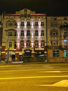 um grande edifício com luzes ao lado de uma rua em Apartamenty Katowicka 58 - self check in 24h - by Kanclerz Investment em Chorzów