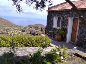a stone house with a door and flowers at Casa bonita in Betenama