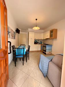 una cucina e un soggiorno con tavolo e sedie di {Perla d'aMare ~ Zaffiro} Appartamento sul mare a San Benedetto del Tronto