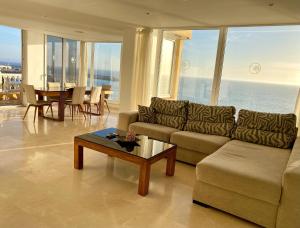 ein Wohnzimmer mit einem Sofa und einem Tisch in der Unterkunft Beach Point Ocean View Suite in Arguineguín