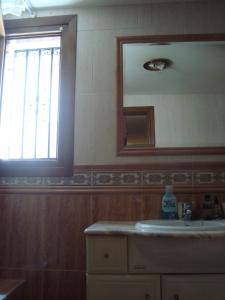 baño con lavabo, espejo y ventana en Peña Telera, en Panticosa