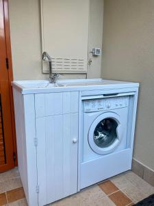 una lavatrice con un lavandino sopra di {Perla d'aMare ~ Zaffiro} Appartamento sul mare a San Benedetto del Tronto