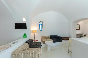 ein Wohnzimmer mit 2 Sofas und einem TV in der Unterkunft Crown of Fira in Firostefani