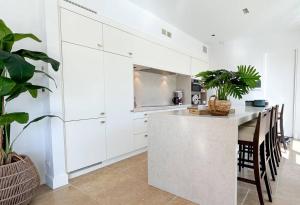 a kitchen with white cabinets and a table with chairs at Grimaud villa in Grimaud